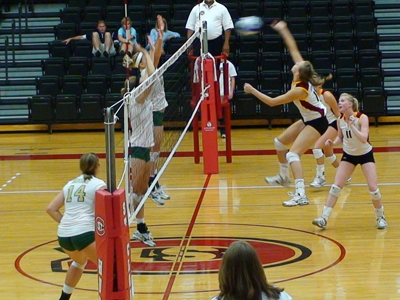 Ferris' Danielle Hamilton  (#15) hammers the ball on an attack in Saturday's win over Missouri S&T as setter Samantha Fordyce (#11) looks on.